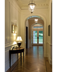 Interior: main hall with raised panel walls and eliptical cased openings 