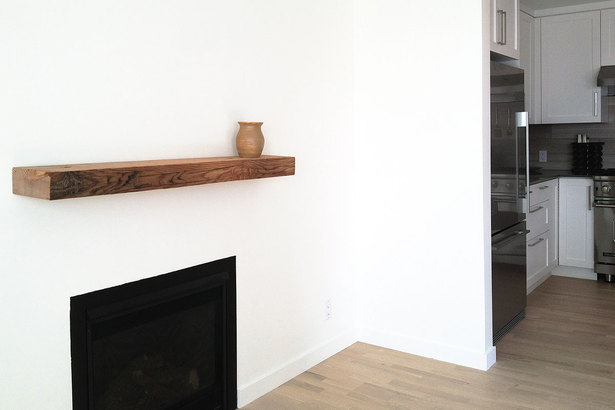 minimalist fireplace with reclaimed wood mantle at the main living space