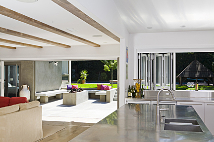 The living room directly adjacent to the kitchen now has a full height bi-fold door rear wall, that opens to a new rear patio space, complete with a fire pit and wooden bench seating. 