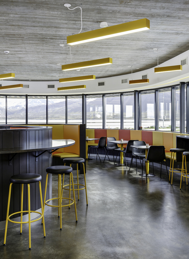 An elongated bar-desk transforms into seating arrangements and characterizes the semicircular restaurant