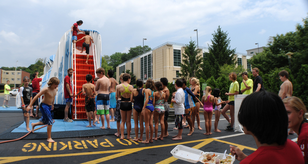 PURIFLUME in operation. From left to right a child is exiting the basin area, an UDBS member explains the systems in the visual void to a student, a child ascends the entrance stair to the slide, C-MITES in queue. PURIFLUME Deployment June 22 2012.