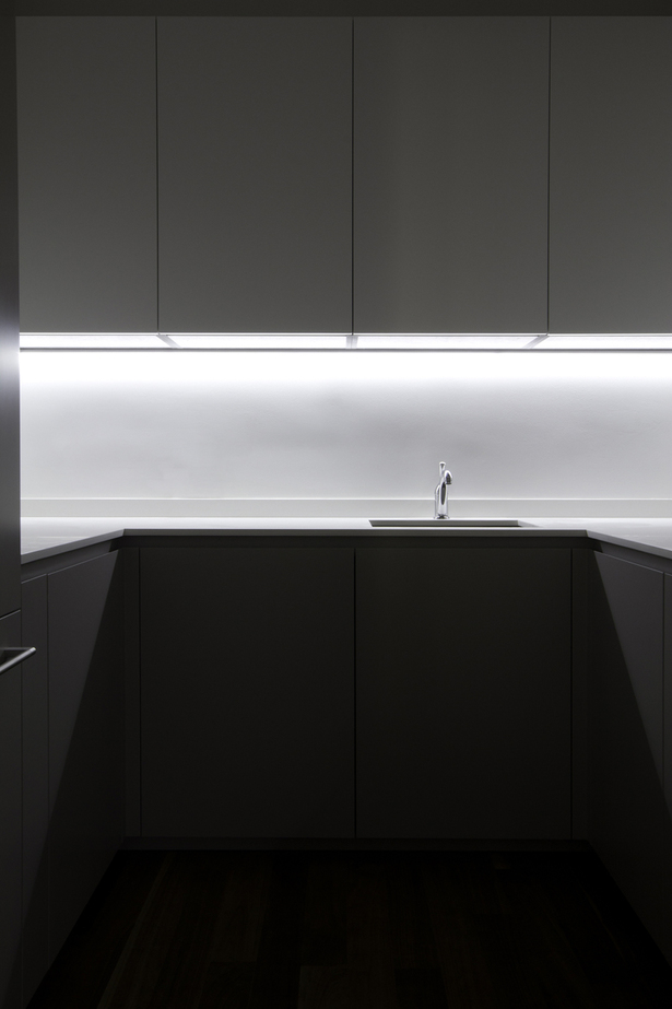 Hidden to the left is a small pantry of 6 square meters; despite its small dimension, the efficient design has made possible the inclusion of: refrigerator and freezer, microwave, oven, a secondary sink and more cabinets that enable the main kitchen to maintain its minimalist aesthetic and the clutter to be hidden away.