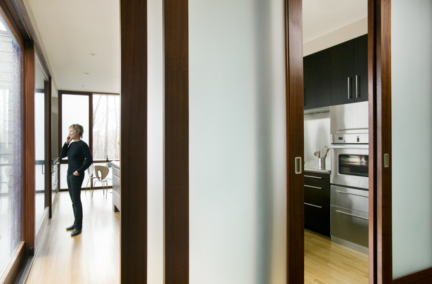 Detail view through translucent doors into kitchen to treetop view
