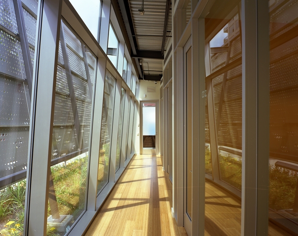On the inside, smooth, luxurious warm tones of wood, leather and color delight the senses. The structural rhythm of the building is slim and narrow, supportive of distinctly human proportions. The spaces are defined by gently sloping surfaces of metal, glass, wood and gypsum. (photo by Greg Murphey)