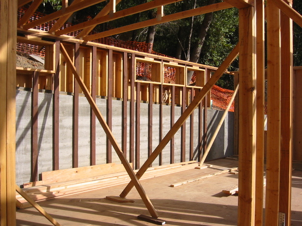 Stick framing with furring at uphill retaining wall. 