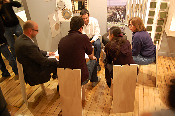 Chairs in use during critique allow for a conversation in the context of a crowded gallery.