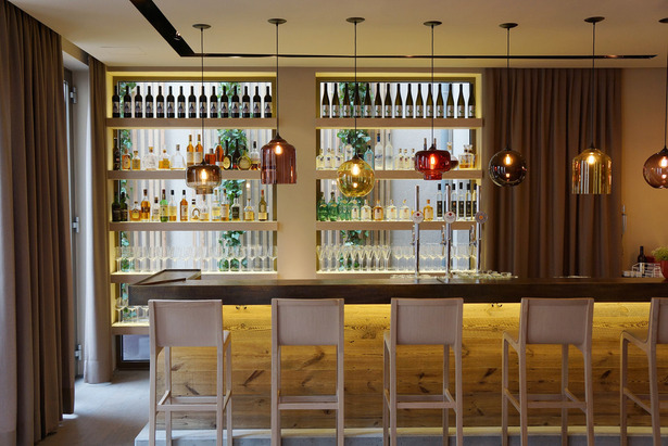 The bar, made of concrete, wood and hammered metal. Behind the rack the 
