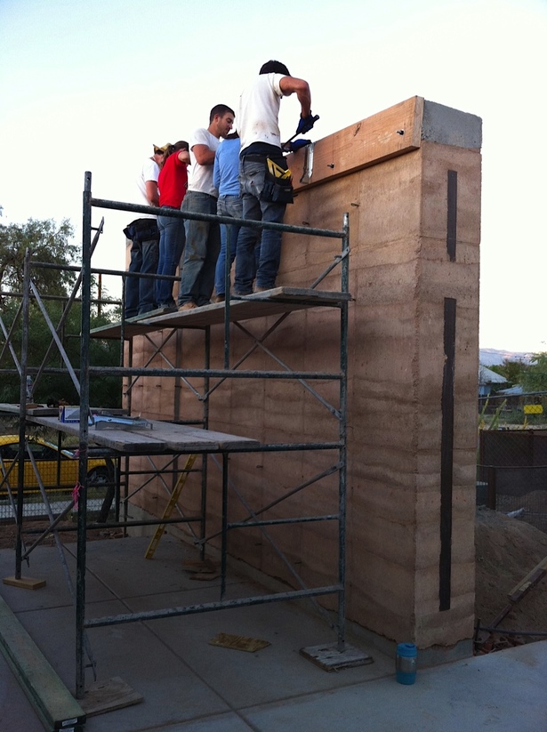 attaching ledgers for roof construction on completed rammed earth wall
