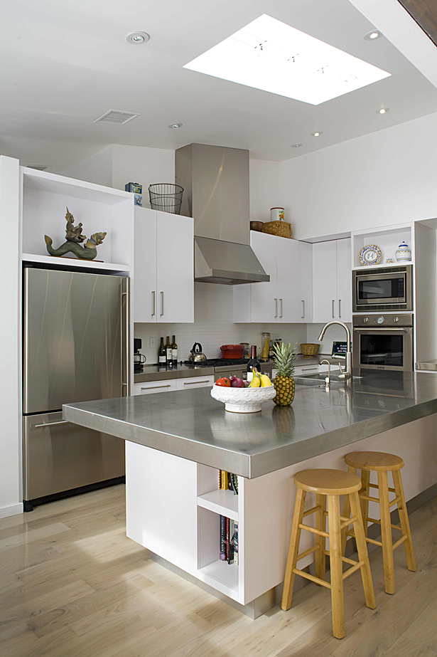 The kitchen area was completely opened up to the living room by reorienting it, raising the ceiling to match the sloped roof above, adding a large central skylight and introducing a small breakfast nook at the southeastern corner of the house.