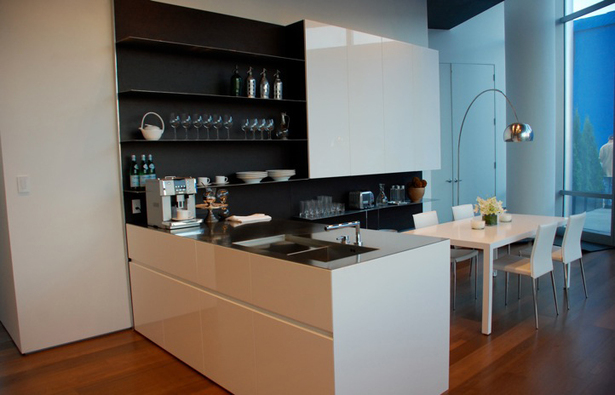 Doors: White Glossy lacquer, 22 mm (3/4”) thick with 30° top edge Sliding Counter: Thermo Oak with electronic movement (counter thickness 8cm = 3 1/8”) Counters: Hand crafted brushed stainless steel, 3 mm (1/8”) thick with soldered sinks and retractable faucet Hood: Custom by Minimal Open Shelving: Thin stainless steel shelving system 6mm (1/4”) thick with Thermo oak back panels