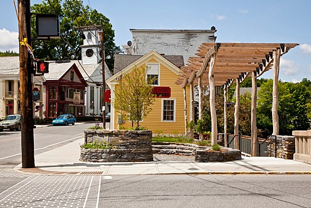 The gentle undulation of the pergola roof was scaled to slip into the eave of the classic New England architecture next door.