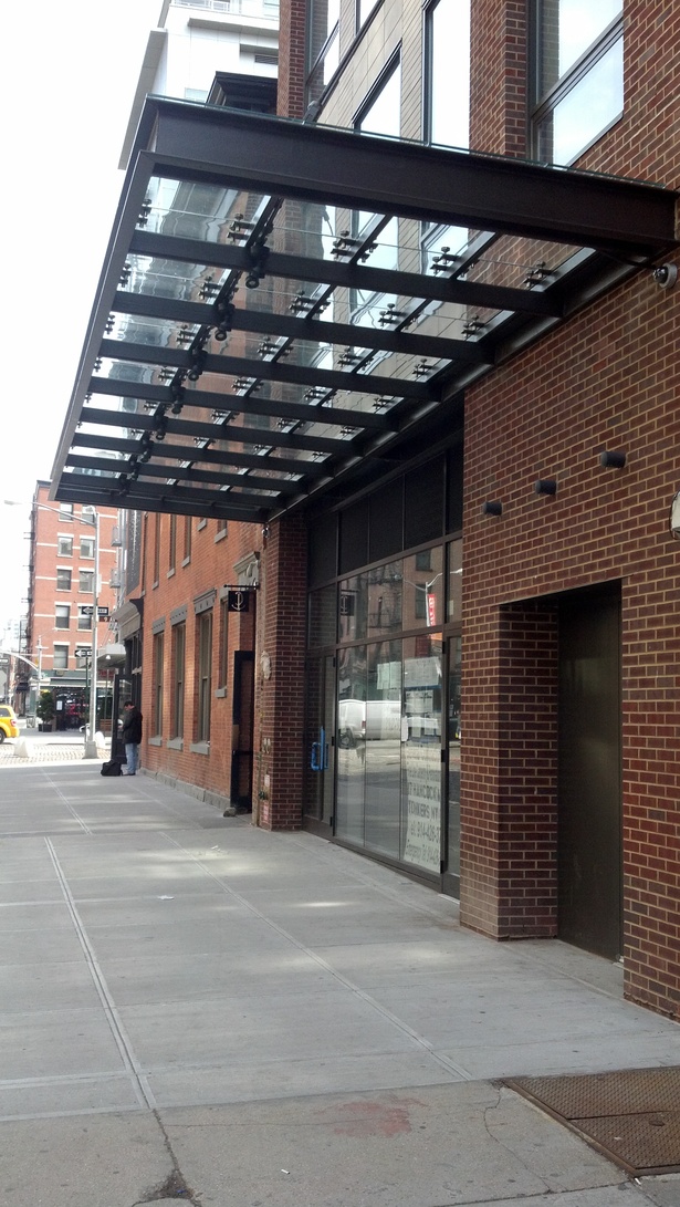 View of front entry and glass and steel canopy