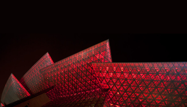 At night time the perforated wing surfaces expose the space truss structures of the wings. The color of the LED lighting is changeable so that the building has a different appearance on different performance nights. (Photo: Jussi Tiainen)