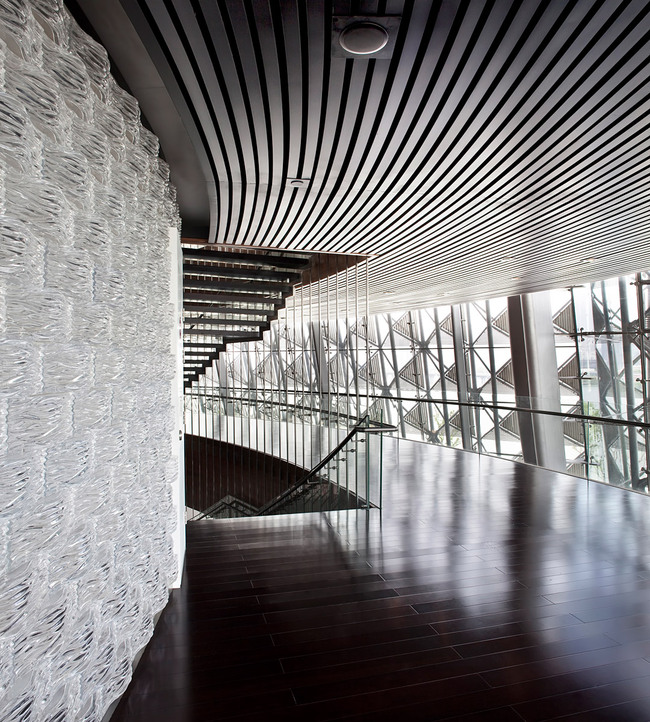 The glass brick wall in the main auditorium lake side lobby is made of 20.000 glass bricks with a wave pattern relating to the surrounding lake and to the curved bamboo block wall inside the auditorium. (Photo: Kari Palsila)