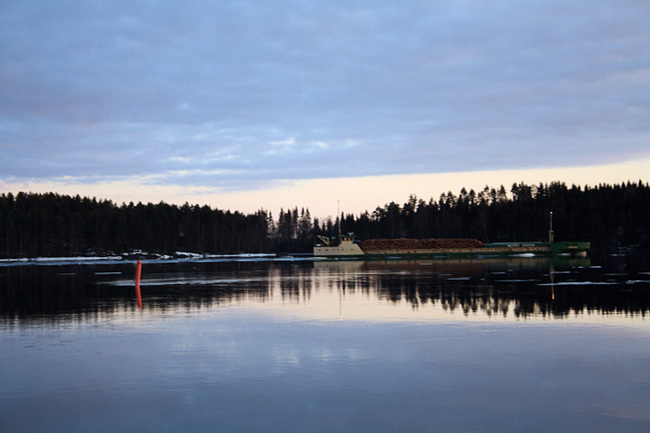 Logging boat gliding quietly through the lakes in Savonlinna, Finland.