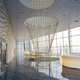 The lake side lobby of the small auditorium. This elevated space is providing great views over the Wuli Lake. The auditorium is accessed via two levels which are connected by a suspended spiral staircase. The entrance wall to the auditorium is covered with special designed CNC cut stone blocks relating to the angulated black brick wall inside the auditorium. (Photo: Jussi Tiainen)